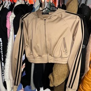 Cropped tan zip long sleeve hoodie with black stripes on sleeves.
